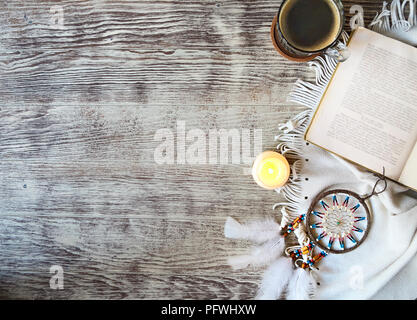 Tasse de café d'un séjour par le livre, bougie, Dream Catcher sur la table en bois. Style Boho Banque D'Images