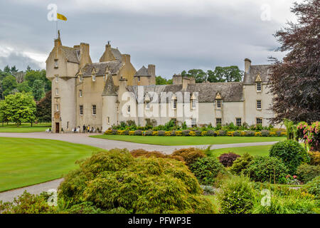 BALLINDALLOCH CHÂTEAU SPEYSIDE ECOSSE TOURISTES PRÈS DE L'ENTRÉE DU CHÂTEAU ET UN JARDINIER SOIGNER LES FLEURS DOUBLES Banque D'Images