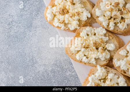 Snack-bruschetta avec le fromage cottage, le noyer et le miel. Banque D'Images