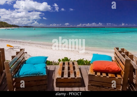 Bancs en bois avec des oreillers colorés dans un bar sur une plage sur l'île Maurice Banque D'Images