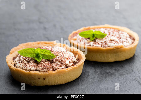 Mini Tartes Tarte banoffee isolé sur fond noir en noir Banque D'Images