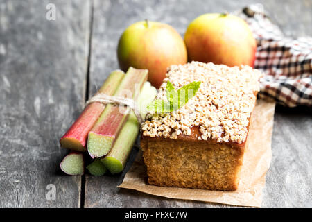 Gâteau aux pommes maison garnie de confiture de rhubarbe et adouci l'avoine sur table en bois Banque D'Images