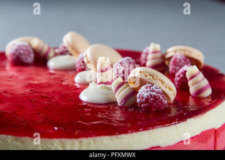 Décoration avec des framboises, des chocolats et des biscuits sur un gâteau Banque D'Images