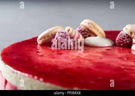 Décoration avec des framboises, des chocolats et des biscuits sur un gâteau Banque D'Images