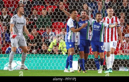 La volonté de Wigan Athletic Grigg (troisième à droite) fête marquant son premier but de côtés du jeu avec ses coéquipiers comme Stoke City gardien Jack Butland (gauche) réagit au cours de la Sky Bet Championship match au stade de bet365, Stoke. Banque D'Images