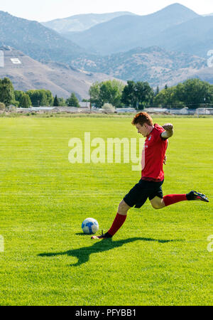 Teenage boy kicking soccer ball ; jeux ; Ben Oswald Park ; Salida ; Colorado ; USA Banque D'Images