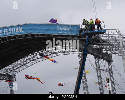 Trois travailleurs d'une grue à l'huilding d'une scène pour un festival de musique Banque D'Images