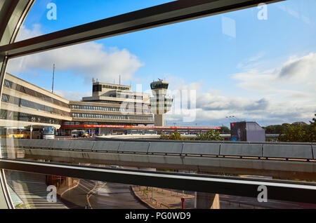 Berlin, Allemagne - 15 août 2018 : l'aéroport de Tegel bâtiment principal et tour de contrôle du trafic aérien vu à travers une fenêtre dans la matinée. Banque D'Images