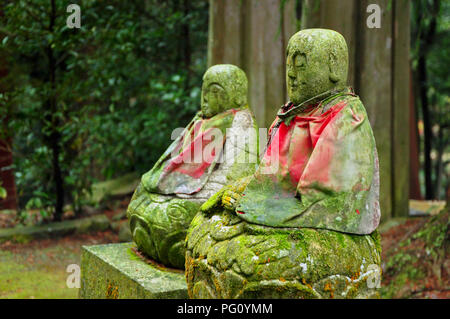 Vieux vert moussu (Jizo Bodhisattva) statues avec manteau rouge près de petits temples sur le mont Shosha, Himeji, Japon Banque D'Images