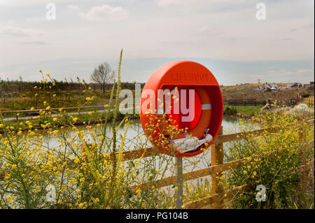 Bouée orange attaché à balustrades en bois donnant sur un lac dans le Hertfordshire Banque D'Images