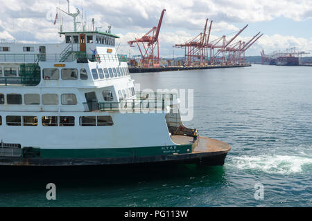 Washington State ferry boat de quitter le terminal de Seattle avec les grues du port de Seattle dans l'arrière-plan, USA. Banque D'Images