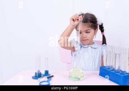 Cute little girl in school uniform remue test tube ou flacon de laboratoire.focus sélectif et et le concept de droit Banque D'Images