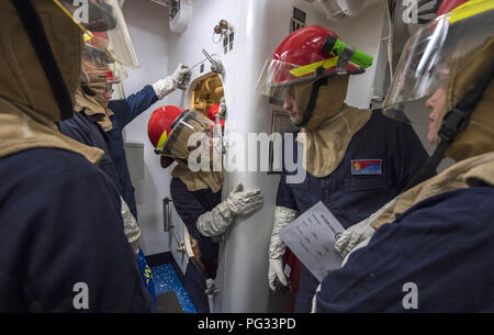 Mer de Chine orientale. Août 21, 2018. Mer de Chine orientale (août 21, 2018) relais marins les messages d'une simulation de l'inondation pendant un exercice de contrôle des dommages de l'équipe de formation à bord de la classe Arleigh Burke destroyer lance-missiles USS Benfold (DDG 65). Benfold est l'avant-déployés dans la 7e flotte américaine zone d'opérations à l'appui de la sécurité et de la stabilité dans la région Indo-Pacifique. (U.S. Photo par marine Spécialiste de la communication de masse 2e classe Elesia Patten/relâchée)180821-N-WM NOUS globallookpress.com647-1079 Marine via Crédit : US Navy/Fédération de regarder/ZUMA/Alamy Fil Live News Banque D'Images