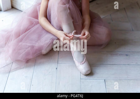 Belles jambes de jeune ballerine qui met sur les pointes à l'étage en bois blanc, arrière-plan, Vue de dessus du dessus avec copie espace. La pratique de ballet. Beaux pieds gracieux slim de danseur de ballet. Banque D'Images