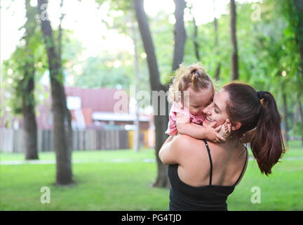 Portrait de la jeune femme s'entraîner avec son bébé dans le parc Banque D'Images