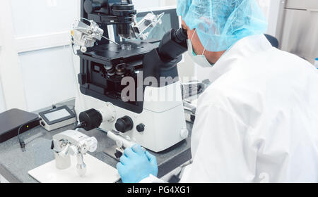 Médecin ou scientifique à la recherche en laboratoire microscope thru Banque D'Images