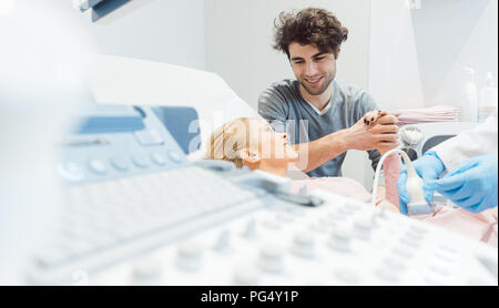 Heureux couple avec femme enceinte au gynécologue Banque D'Images