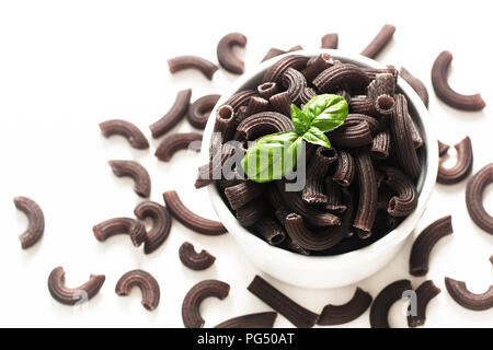 Concept alimentaire l'encre de seiche ou noir pâtes penne en coupe blanche sur fond blanc Banque D'Images