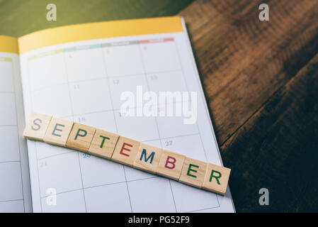 Gros plan du planificateur sur tuile alphabet septembre calendrier livre sur table en bois . Le mois de septembre et la planification de concept Banque D'Images