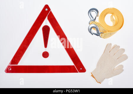 Mise à plat avec panneau d'avertissement, des gants et un câble de remorquage isolated on white Banque D'Images