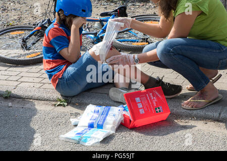 Photo symbolique, infirmerie, scène posés, les soins des plaies, après un accident de vélo, Wounded Knee, le bandage est créé, avec des bandages à partir de la boîte de premiers secours de Banque D'Images