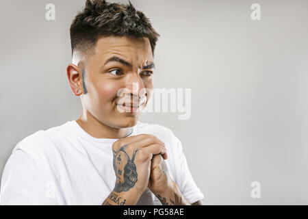 Ew. Il est si brut. Jeune homme avec l'expression dégoûtée repousser quelque chose. Concept de dégoût. Jeune homme émotif. Les émotions humaines, l'expression faciale concept. Studio. Isolé sur gray Banque D'Images