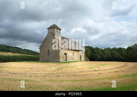 Langley Chapel, Acton Burnell, Shropshire, Angleterre, Royaume-Uni. Vu après le champ de maïs, dans lequel il se trouve, a été moissonné. Ciel menaçant au-dessus Banque D'Images