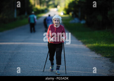 Une femme âgée a engagé dans la marche nordique avec des bâtons. Banque D'Images