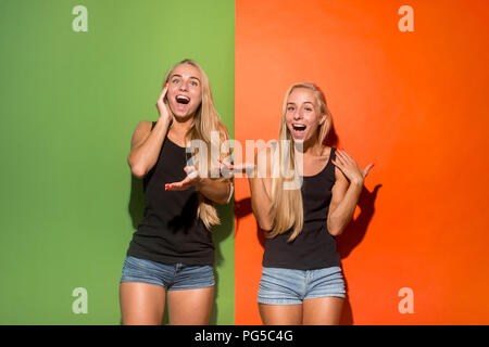 Happy women standing and smiling isolé sur fond de studio. Belle femme portrait de mi-longueur. Les jeunes femmes émotionnelle. Les émotions humaines, l'expression faciale concept. Vue de face. Banque D'Images