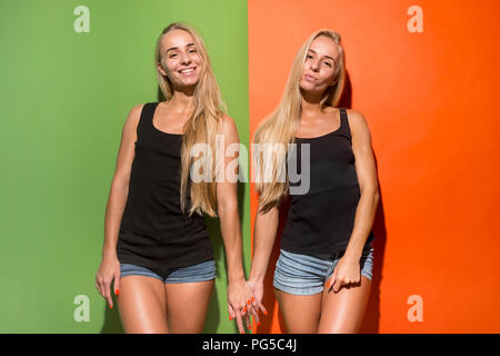 Happy women standing and smiling isolé sur fond de studio. Belle femme portrait de mi-longueur. Les jeunes femmes émotionnelle. Les émotions humaines, l'expression faciale concept. Vue de face. Banque D'Images