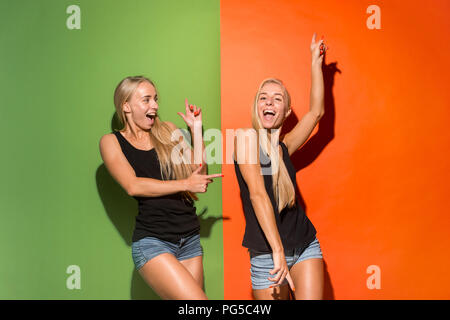 Happy women standing and smiling isolé sur fond de studio. Belle femme portrait de mi-longueur. Les jeunes femmes émotionnelle. Les émotions humaines, l'expression faciale concept. Vue de face. Banque D'Images