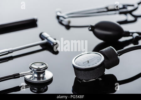 Focus sélectif de marteau réflexe, tonomètre et stéthoscope sur surface en verre Banque D'Images