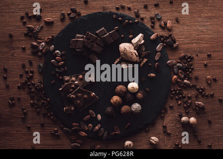 Portrait de découper avec divers types de pièces en chocolat et truffes entouré par les fèves de cacao, café et de muscade sur tabl Banque D'Images