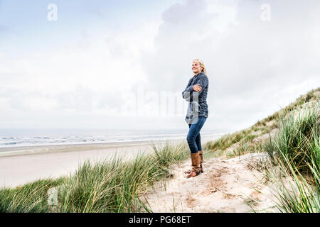 Smiling woman standing in dunes Banque D'Images