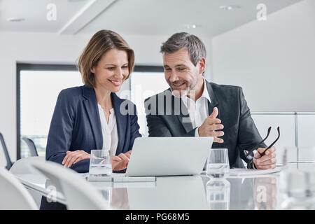 Businessman and businesswoman having a meeting in office with laptop Banque D'Images