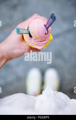 Woman's hand holding ice cream cone avec deux boules et cuillères Banque D'Images