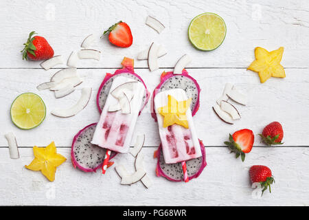 Des exocitic les fruits, coconut ice lollies, caramboles, chaux, dragonfruit Gajewski, chips de noix de coco et fraises Banque D'Images