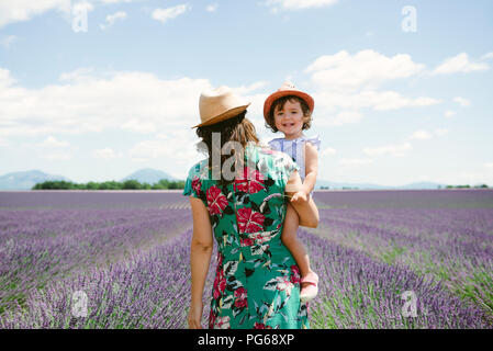 France, Provence, plateau de Valensole, Mère et fille marcher parmi les champs de lavande en été Banque D'Images
