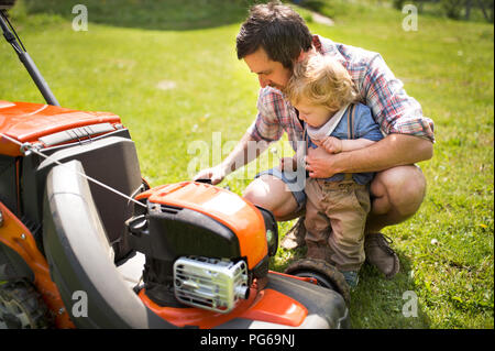 Père avec son petit fils et tondeuse Banque D'Images