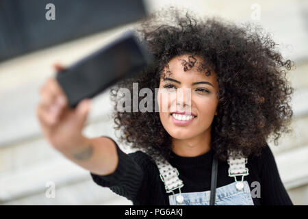 Portrait of smiling young woman with smartphone selfies Banque D'Images