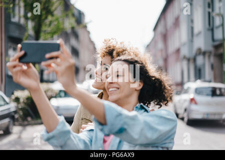 Meilleurs amis prendre des autoportraits avec un smartphone dans la ville Banque D'Images