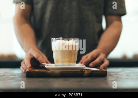 Waiter serving Latte Macchiato dans un café-bar Banque D'Images