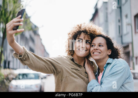 Meilleurs amis prendre des autoportraits avec un smartphone dans la ville Banque D'Images