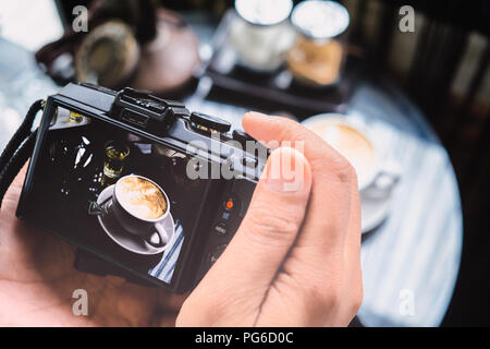 Atelier de photographie blogging concept. Tenir la main de caméra café au café. Banque D'Images