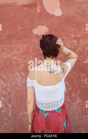 Vue arrière d'une jeune femme aux cheveux rouge courte tête toucher la main Banque D'Images