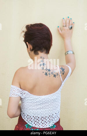 Vue arrière d'un mur de toucher la main femme souligné Banque D'Images