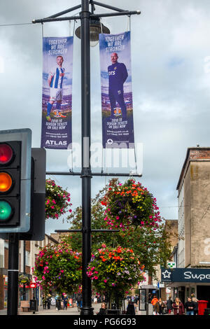 King Street, rue commerçante de Kilmarnock, East Ayrshire, Ecosse, avec paniers suspendus et bannières saison publicité Billets pour FC Kilmarnock Banque D'Images