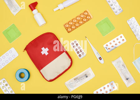 Vue de dessus de trousse de premiers soins avec différents médicaments isolé sur le jaune Banque D'Images