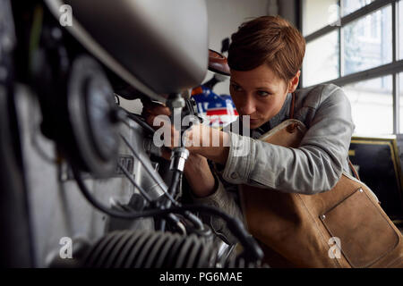 Femme travaillant en atelier de réparation Banque D'Images