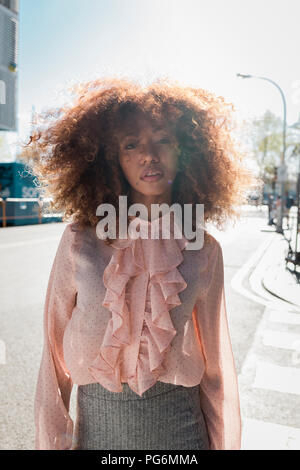 Portrait de la belle jeune femme à la coiffure afro dans la ville Banque D'Images